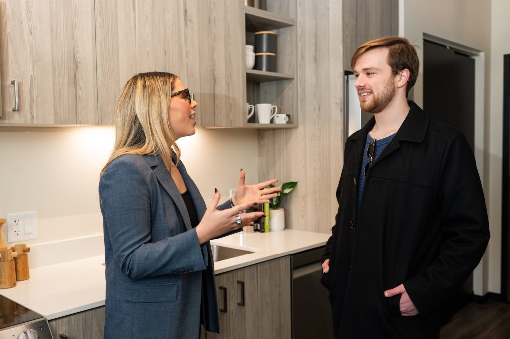 A real estate broker gives a tour of a home to a prospective tenant.