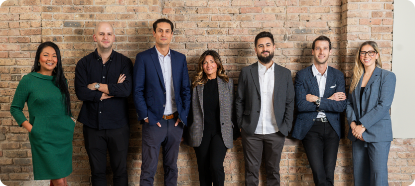 Members of the leadership team at Cross Street stand against a brick wall. From left to right: Jodi Dougherty, Director of Broker Development. Michael Horwitz, Managing Broker. Oren Pollack, VP of Sales. Erin Higgins, National Director of Leasing. Ari Weil, VP of Operations. Shane Rachman, President and Founder. Sarah Jaffe, Sales Leader.