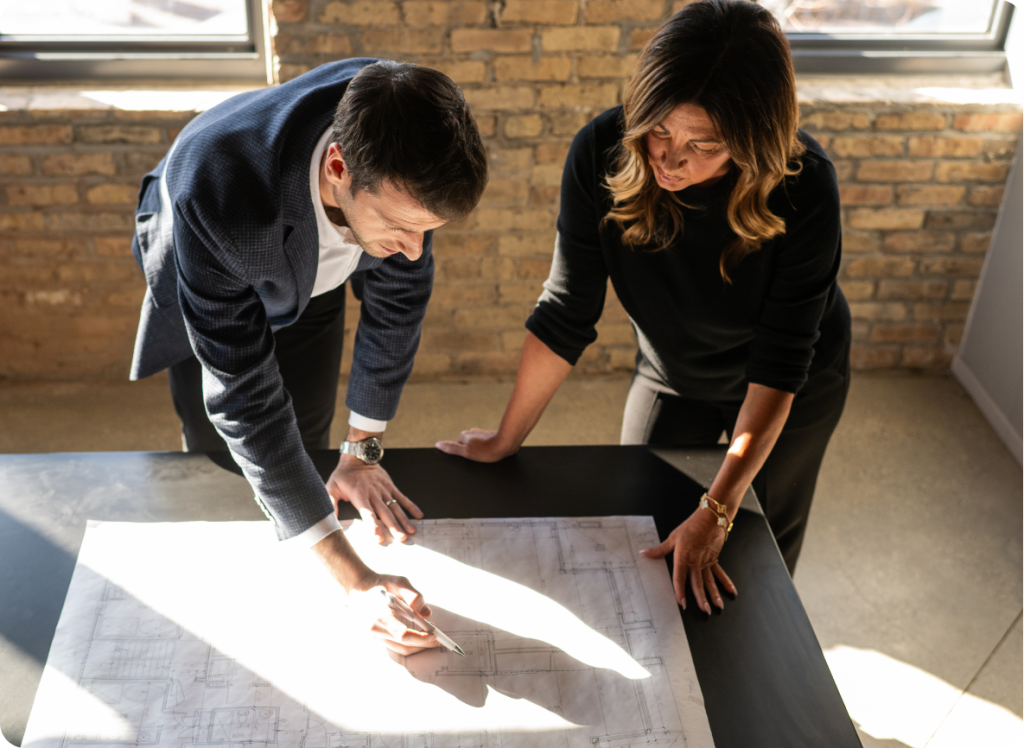 Shane Rachman, President and Founder, and Erin Higgins, National Director of Leasing, analyze floor plans of a multifamily development as part of Cross Street's predevelopment consultation services.